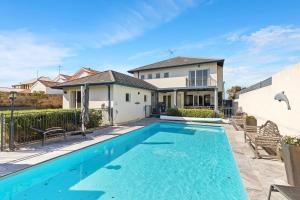 曼哲拉Beachfront Family Favourite Home with Pool & Views的房屋前的游泳池