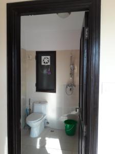 加德满都Drala Resort Nepal的浴室设有卫生间,墙上挂着一幅狗的照片