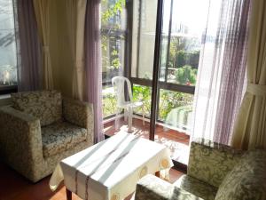 加德满都Drala Resort Nepal的客厅配有桌椅和窗户。