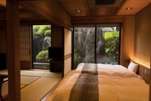 笛吹市Beautiful Japanese Garden Kagetsu的一间卧室设有一张床和一个大窗户