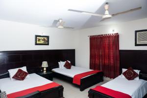 达卡Ali International Hotel的一间设有两张红色和白色床铺的房间