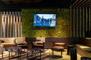 达豪FreshSuites & Bar的墙上配有电视的酒吧