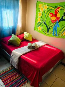阿拉胡埃拉Around Juan Santa María的一间卧室配有两张带红色床单和绘画的床