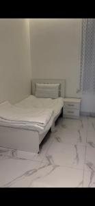 阿尔莎法Altaraf Resort的一间带两张床的卧室,铺有瓷砖地板。