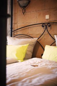 巴特柯尼希祖尔博斯特兰德酒店的一张带黄色和白色枕头的床和砖墙
