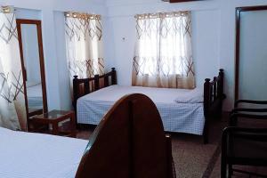 巴纳内拉斯Ashiana Serviced Apartment的一间卧室配有两张床和镜子