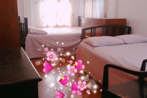 巴纳内拉斯Ashiana Serviced Apartment的一间卧室设有两张床,拥有粉红色的圣诞装饰