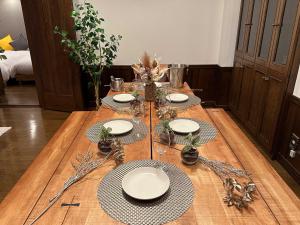 札幌LIT’S INN Sapporo的一张木桌,上面有盘子和玻璃杯