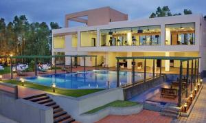 班加罗尔Trinity Hotel Bengaluru的一座大房子,前面设有一个游泳池