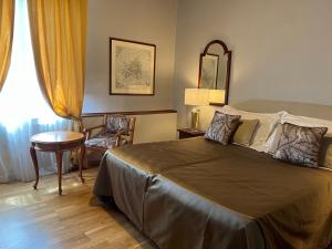 佛罗伦萨维拉尼酒店的卧室配有1张床、1张桌子和1把椅子