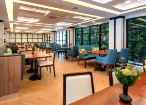 清莱Sann Hotel的餐厅设有桌椅和窗户。