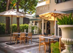 清莱Sann Hotel的一个带桌椅和遮阳伞的户外庭院。