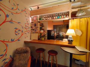 大阪Guest House mii的一间酒吧,里面设有两张凳子和一个柜台