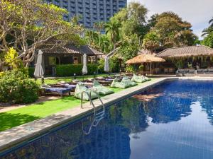 北芭堤雅Let's Hyde Pattaya Resort & Villas - Pool Cabanas的一个带躺椅的游泳池,一个度假村
