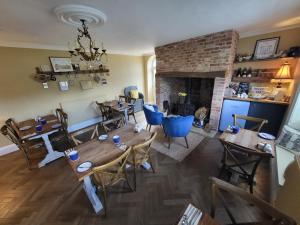 丹佛Belle Vue Guest House的客厅配有木桌和壁炉