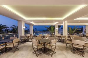 卡尔扎迈纳Porto Bello Beach Hotel的一间带桌椅的海景餐厅