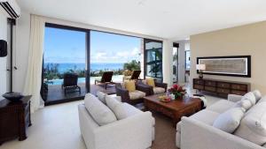 加拉班Navy Hill Resort的客厅配有白色家具,享有海景。