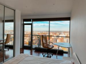 维尔纽斯Panoramic Apartment Vilnius的卧室配有一张床和一张桌子及椅子