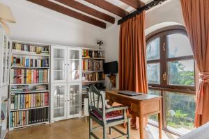 圣卡洛斯Villa Can Sarrio的一个带桌子和书架的家庭办公室