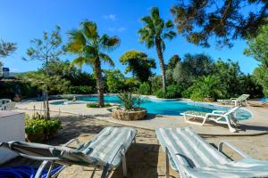圣卡洛斯Villa Can Sarrio的一个带两把草坪椅和棕榈树的游泳池