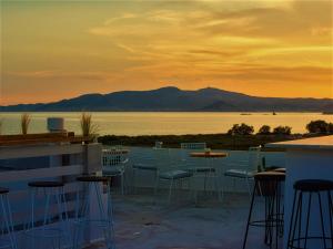 布拉卡Studios Vrettos Beachfront Hotel的一个带桌椅的庭院,享有水景