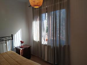 龙奇廖内roncio' cottage的一间卧室配有床和带窗帘的窗户