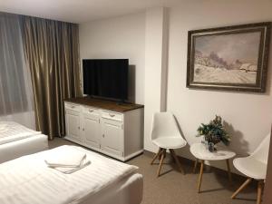 佩济诺克HOTEL GALERIA PEZINSKA BABA的一间卧室配有一张床和一台平面电视
