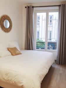 巴黎New Apartment in the Heart of Le Marais的一间卧室设有一张床和一个大窗户