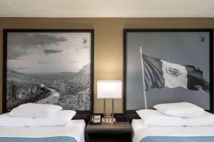 拉雷多Super 8 by Wyndham Laredo的酒店客房,设有两张床和一面旗帜