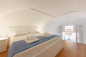 普罗奇达TORRETTA CORRICELLA - Punta Miseno的白色卧室,配有带毛巾的床