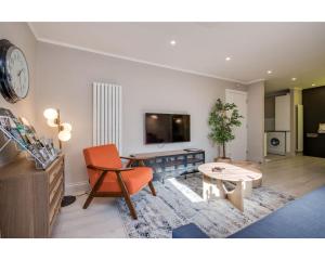 贝尔法斯特Central Belfast Apartments: Citygate的客厅配有橙色椅子和桌子