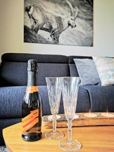 圣莫里茨Sankt Moritz Spirit Piz Bernina 5的一瓶香槟和一张桌子上的两杯酒