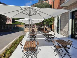韦内雷港格拉兹酒店的一组桌子和椅子,放在伞下