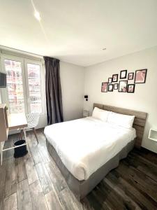 尼斯贝尔纳酒店的卧室配有一张白色大床和一张书桌