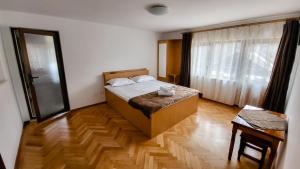 科尔贝尼Pensiunea Tesoro的一间卧室配有一张床,铺有木地板