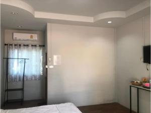 坤西育府Capital O 75412 V Resort的一间卧室配有一张床,墙上配有电视