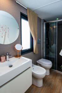 拉齐塞Piani di Clodia Holidaypark的一间带水槽、卫生间和镜子的浴室