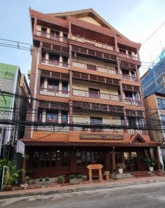 Ban NongdouangKhampiane1 Hotel的一座大型木制建筑,位于城市街道上,设有阳台