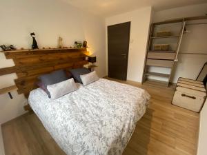克松吕-隆日梅Les écureuils的一间卧室配有一张大床和木制床头板