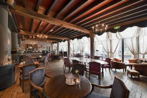 海尔肯博斯Romantik Hotel Kasteel Daelenbroeck的餐厅设有木制天花板和桌椅