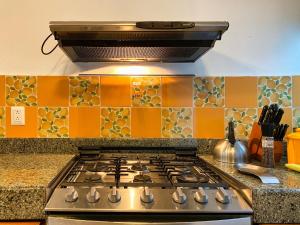坎昆Humant Coliving - Cancún的厨房配有橙色瓷砖和炉灶