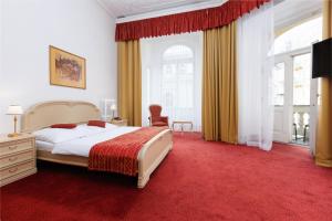 玛丽亚温泉OREA Spa Hotel Palace Zvon Mariánské Lázně的一间卧室配有一张大床和红地毯
