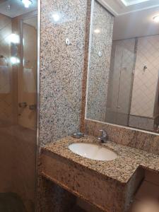 巴西利亚Lets Idea Hotel Flat Particular的浴室配有盥洗盆和带镜子的淋浴