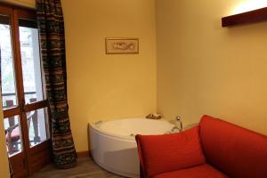 利莫内皮埃蒙特普林斯普大酒店的配有红色沙发的客房内的浴缸
