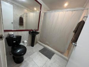 奥拉涅斯塔德Pista Q hostel and apartments的一间带黑色卫生间和淋浴的浴室