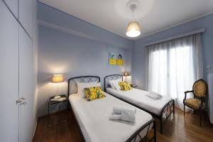 雅典Spacious 3 Bedroom apt near Acropolis museum的一间卧室设有两张床和窗户。