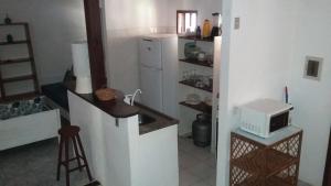 因巴塞Imbassai Flat的厨房配有白色冰箱和微波炉