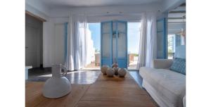 皮索利瓦迪Morfia Villas的客厅配有白色沙发和蓝色门