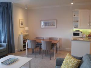 阿伯蒂费Beautiful Aberdovey Seafront Apartment 2的厨房以及带桌椅的起居室。