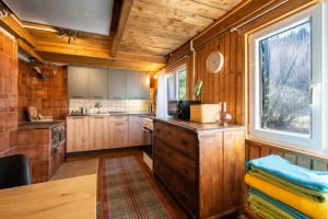 LučivnáOld Fashioned Cottage in Lopusna dolina near High Tatras的厨房配有木制橱柜和窗户。